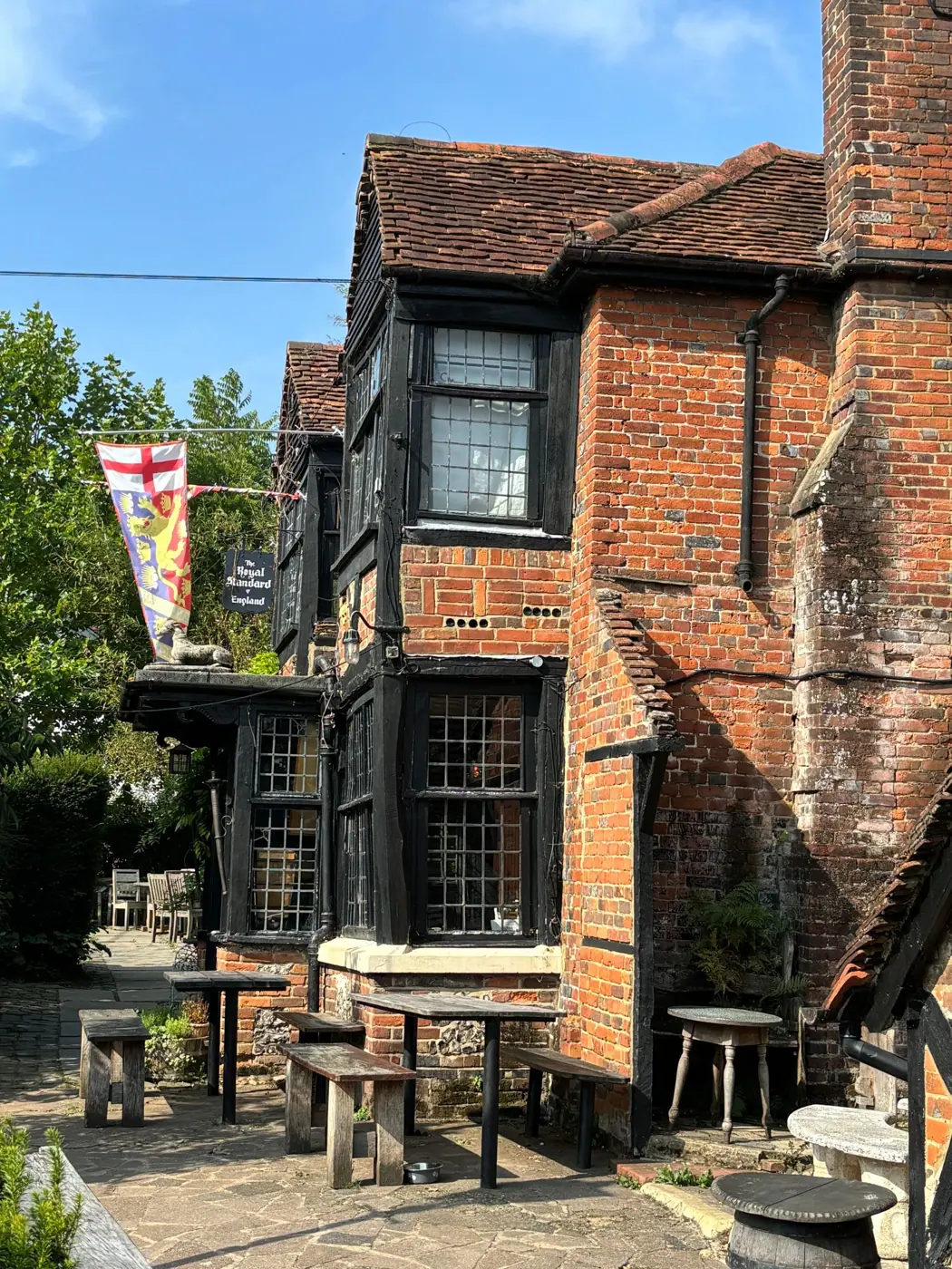 The pub in summer, brick and timber with flags flying